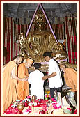 Swamishri instructs devotees to place auspicious articles inside the pit of the main seat