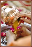 ... and bathes Shri Harikrishna Maharaj in holy water