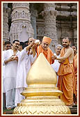 Swamishri helps Yogi, a young boy who is one among several youths from USA, perform abhishek