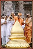 Swamishri helps Yogi, a young boy who is one among several youths from USA, perform abhishek