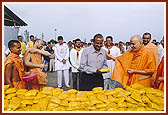 During the flood-relief program Swamishri on behalf of BAPS chapter of Jamnagar offers 10,000 food packets to the Collector