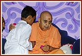 Swamishri blesses a child for getting an award in Satsang