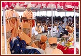 Swamishri, with Thakorji, in the boat, performs five pradakshinas. After each pradakshina Swamishri and senior sadhus perform arti of Thakorji