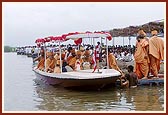 Swamishri, with Thakorji, in the boat, performs five pradakshinas. After each pradakshina Swamishri and senior sadhus perform arti of Thakorji