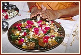 Performs pujan of the gold yantras and silver forms of sheshnag and kurma, panchratna, panchdhatu, and yantra that symbolize the elements of nature, for Pindika pujan 