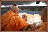 Swamishri performs pujan and showers flower petals to sanctify a replica of Bhagwan Swaminarayan's charnarvind (holy feet) to be placed outside the reception center at Swaminarayan Akshardham