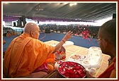Swamishri performs pujan and showers flower petals to sanctify a replica of Bhagwan Swaminarayan's charnarvind (holy feet) to be placed outside the reception center at Swaminarayan Akshardham