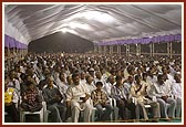 Devotees listen to the evening spiritual discourse