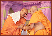 Swamishri honors Pujya Satyamitranand Swami with a shawl