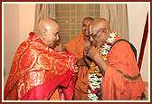 Swamishri garlands Pujya Jeer Swami, Head of Totadri Ramanuj Pith, and he offers a shawl to Swamishri