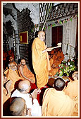 Swamishri performing arti with a traditional divo made from coconut and sugarcane