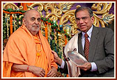 Swamishri blesses and present a memento to a honored guest