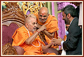 Swamishri blesses Shri Bawa Jain, Secretary General, World Council of Religious Leaders, on the festival stage