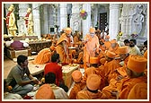 Swamishri blesses all by showering rice grains