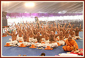 Swamishri and diksha participants raise the janois