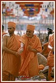 Swamishri blesses devotees by showering rice grains