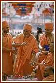 Swamishri blesses devotees by showering rice grains