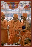 Swamishri blesses devotees by showering rice grains