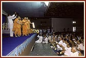 Swamishri blesses devotees by showering rice grains