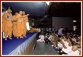 Swamishri blesses devotees by showering rice grains