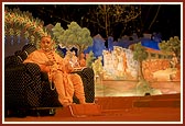 Swamishri on stage with the backdrop depicting different incidents from the life of Bhagwan Swaminarayan 