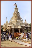 Tribal devotees of Poshina honor and lead Swamishri to the main mandir by playing drums