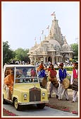 Tribal devotees of Poshina honor and lead Swamishri to the main mandir by playing drums