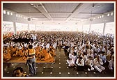 Sadhus and devotees engaged in Swamishri's morning puja darshan in 'Gunatit Mandapam'