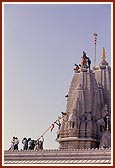 Sadhus and volunteers establish kalash and flagstaff on shikhar (pinnacle)