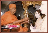 Swamishri holds a mirror for 'mukh darshan' ritual