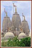 The three shikhars adorned with kalashas and flagstaffs