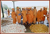 Swamishri minutely inspects prasadam to be distributed after dedication ceremony of two villages constructed by BAPS