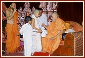 Swamishri gives janoi to a child