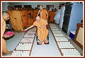 Swamishri sanctifies dudhpak with rose petals to be distributed as prasadam on Shastriji Maharaj Smruti Din