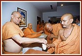 Senior sadhus give the prasadam to sadhus and devotees in the presence of Swamishri