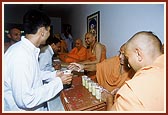 Senior sadhus give the prasadam to sadhus and devotees in the presence of Swamishri