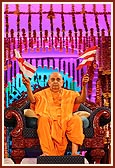 Swamishri waves a BAPS flag for the Sanstha's Centenary Celebration