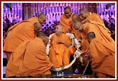 Resident sadhus of London Mandir honor Swamishri with a garland