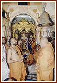 Swamishri sanctifies the new bell by ringing it