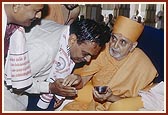 Swamishri blesses the grandson of Keshavlal Shukla (who chanted the mantras for the murti-pratishtha rituals 100 years ago in Bochasan in the presence of Shastriji Maharaj), Shri Ghanshyambhai Karunashankar Shukla, who conducted and chanted mantras of the murti-pratishtha ritual