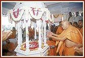 Swamishri performs pratishtha of marble footprints of Bhagwan Swaminarayan in a shrine on the banks of a pond where Shri Nilkanth Varni stayed 