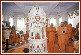 Swamishri performs pratishtha of marble footprints of Bhagwan Swaminarayan in a shrine on the banks of a pond where Shri Nilkanth Varni stayed 