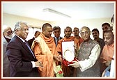 Acharya Swami presents Dr. Singhvi with a commemorative plaque