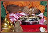 Swamishri ceremoniously bathes Shri Harikrishna Maharaj with panchamrut during the rituals 