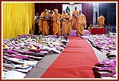 Swamishri showers sanctified flower petals on the account books