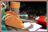 Swamishri writes his blessings in the mandir account book