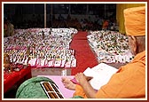   Swamishri writes his blessings in the account book