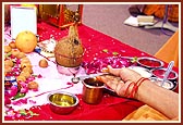 Swamishri takes water in a spoon as part of the concluding mahapuja ritual (Purnahuti Sankalp) 